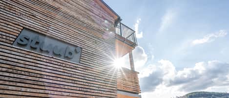 A wooden building with a balcony and a sign that reads "studio".