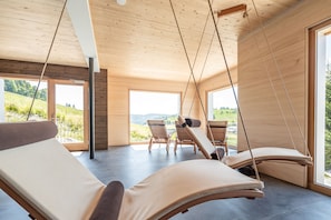 A modern interior with wooden ceiling beams, large windows, and a view of a green landscape. - stuub todtnauberg (Todtnau)