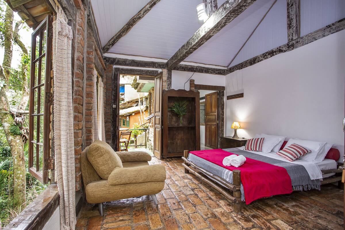 Une pièce confortable avec un lit, une chaise et un plancher en bois.