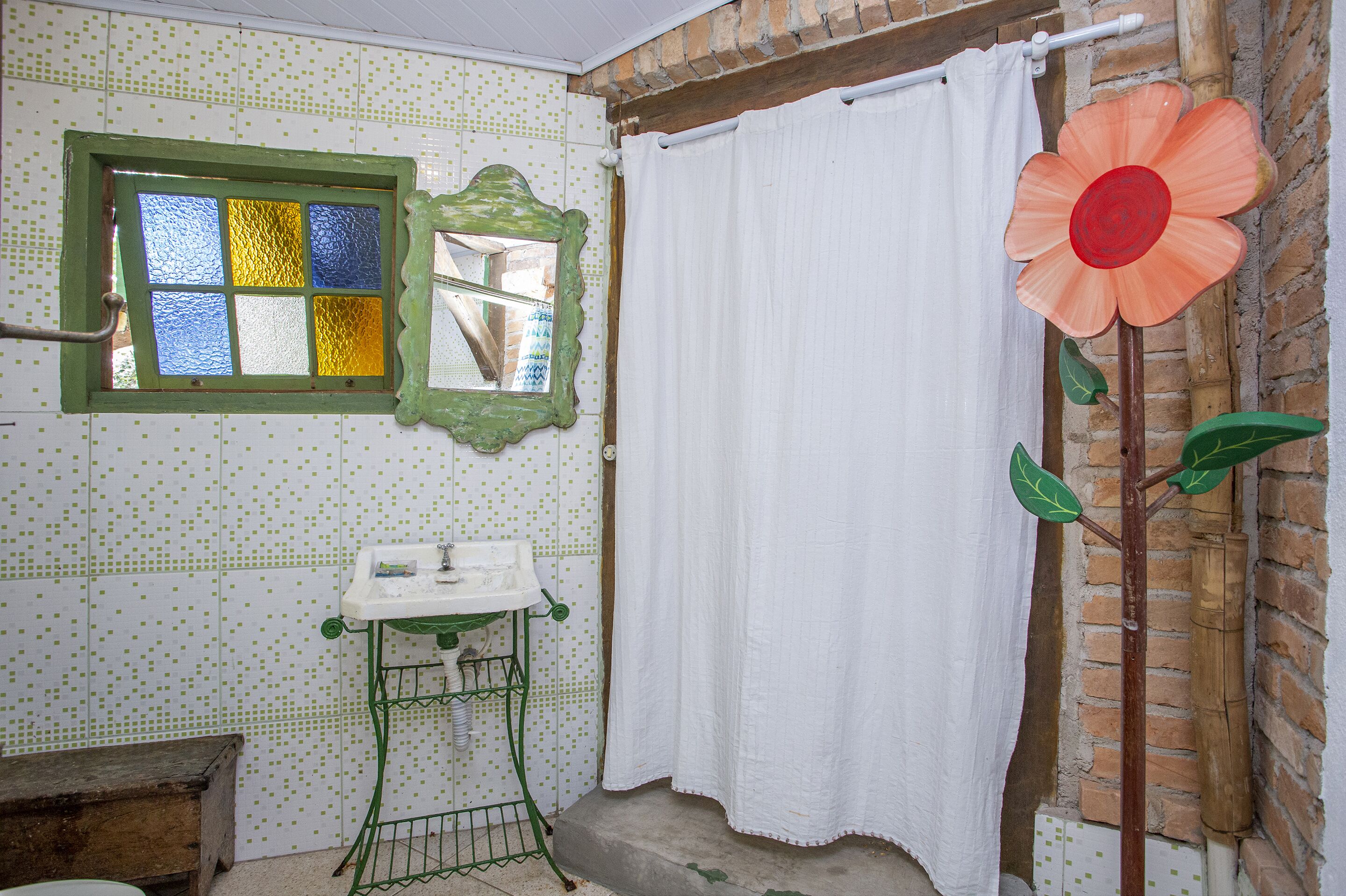 Un baño con ventana, lavamanos y cortina de ducha.