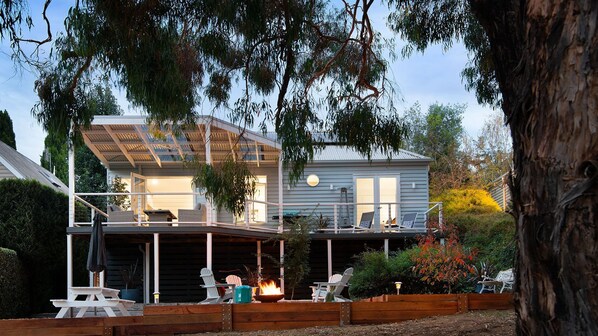 A two-story house with a covered patio area, outdoor seating, and a fire feature. - Vue Lake Daylesford Villa-on the lake (Daylesford)