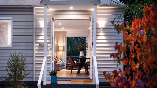 A modern house with a covered porch, a dining area, and a view of the garden. - Vue Lake Daylesford Villa-on the lake (Daylesford)