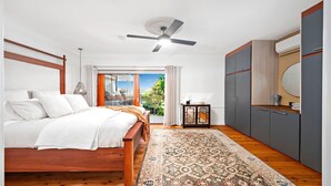 A bedroom with a bed, a ceiling fan, a window with curtains, a nightstand, and a wardrobe. - Nelson Bay CBD Oasis - 13 Government Rd (Nelson Bay)