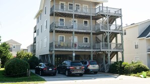 A multi-story building with balconies and a parking area. - Historic charm blended with modern convenience! (Wrightsville Beach)