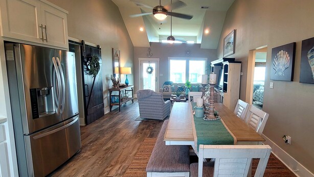 A spacious kitchen with a large island, stainless steel appliances, and a dining area with a wooden table and chairs.