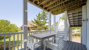 A covered outdoor deck with a table and chairs, surrounded by white railings and a wooden ceiling. - Amazing location and layout for vacation fun! 206 Massachusetts (Lewes)