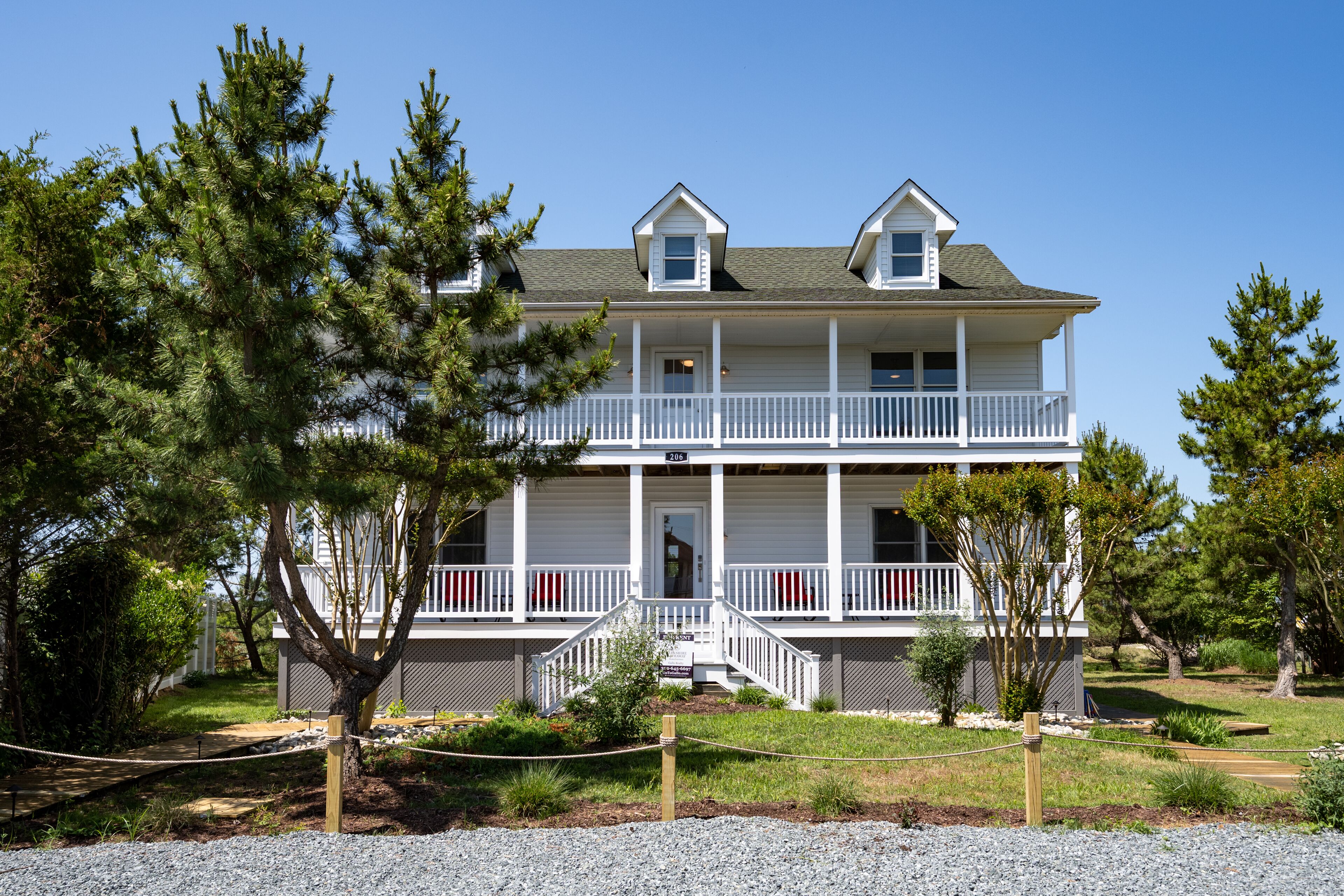 A two-story building with a balcony, a porch, and a small front entrance.