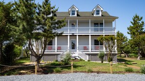 A two-story building with a balcony, a porch, and a small front entrance. - Amazing location and layout for vacation fun! 206 Massachusetts (Lewes)