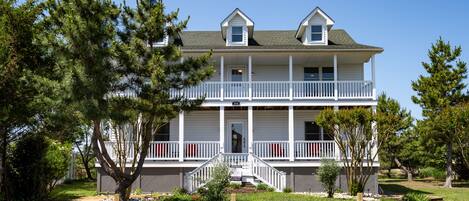A two-story building with a balcony, a porch, and a small front entrance.