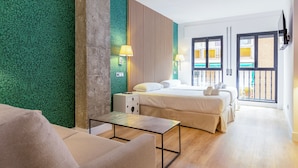 A hotel room with a bed, bedside tables, a desk, and a view of the outside.