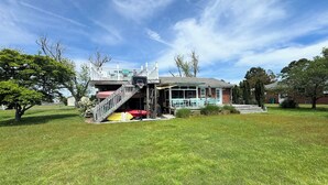 A house with a covered porch, a basketball hoop, and a small deck. - Eel Creek Escape -  Water Front  - Water Access - Screened Porch NO LINENS (Chincoteague)