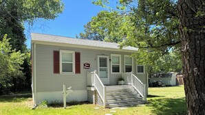 A small, single-story house with a front porch, a mailbox, and a 'Sea Pines' sign. - Sea Pines -2BR  CLOSE TO SHOPPING,SCREENED PORCH, Linens and Towels Provided (Chincoteague)