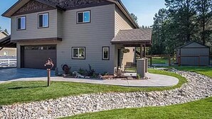 A two-story house with a garage, a covered porch, and a landscaped driveway. - A/C LakeAccess GameRoom Xbox DogOK kayaks paddleboards Private30'Dock Sleeps 14 (Sagle)