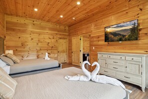 Relax in this inviting room with two beds, a TV, and a dresser for a comfortable stay.