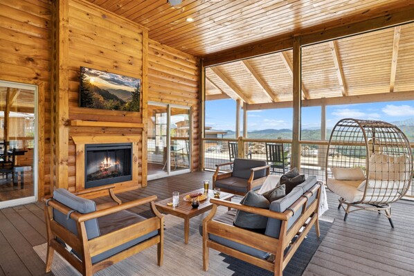Cozy cabin with a fireplace, comfortable seating, and a dining area offering a view of the surrounding landscape.