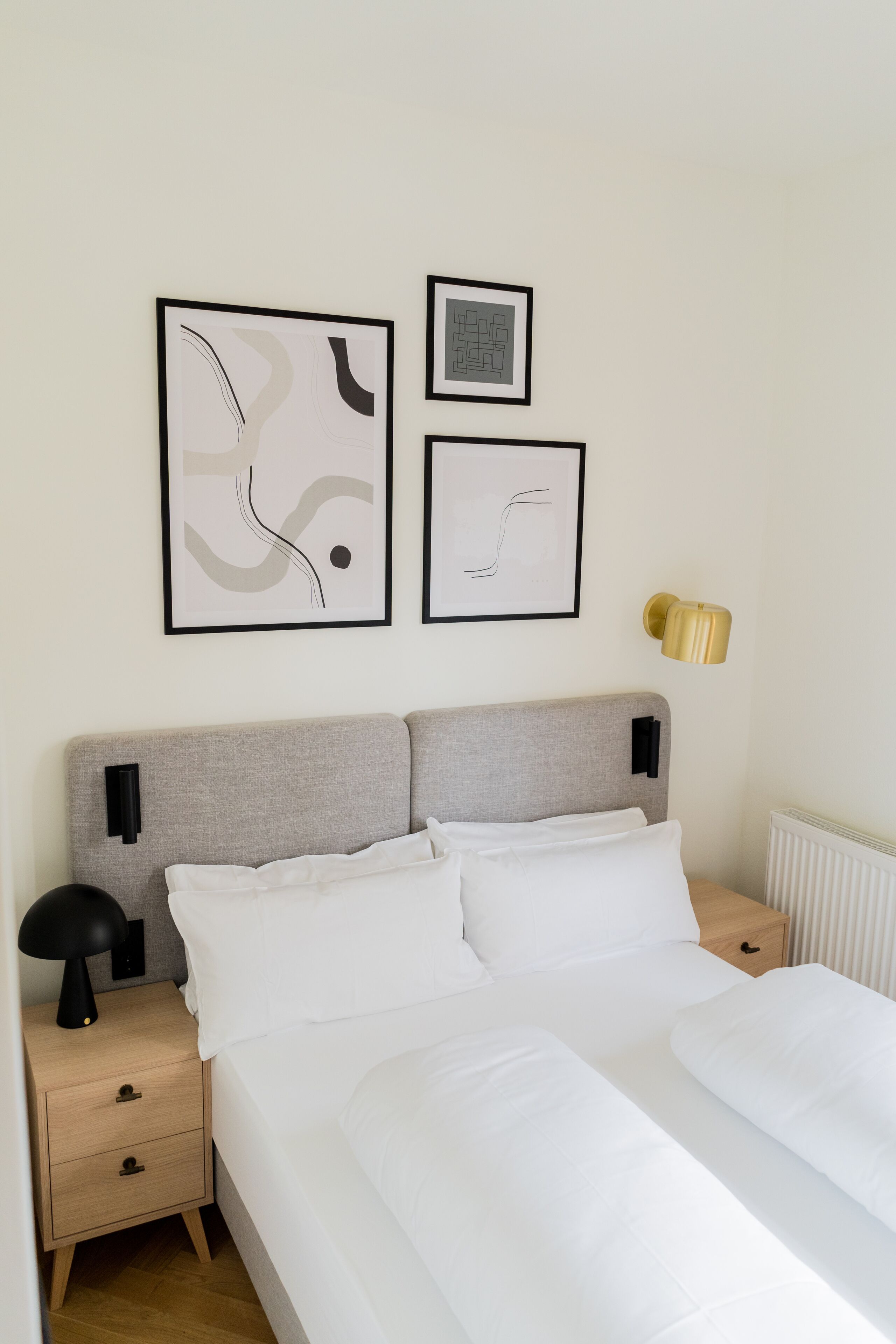 Ein ordentlich eingerichtetes Schlafzimmer mit einem Bett, Nachttischen und einem Wandbild.