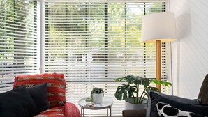 A room with white blinds, a round table with a potted plant, and a floor lamp. - The Black Door Bright, Victoria (Bright)