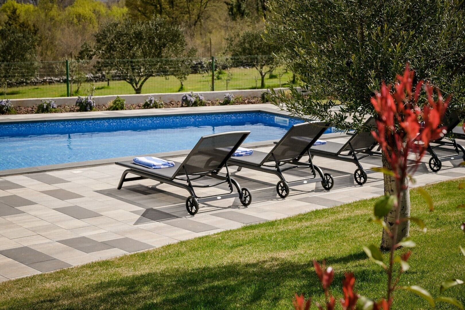 A poolside area with lounge chairs and a swimming pool.