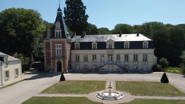 A large, historic building with a symmetrical facade, a central courtyard with a fountain, and a smaller adjacent structure. - Family chateau in the heart of an estate (Flacey)