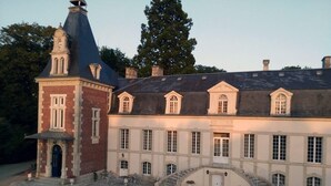 A large, historic building with a prominent tower and multiple windows. - Family chateau in the heart of an estate (Flacey)