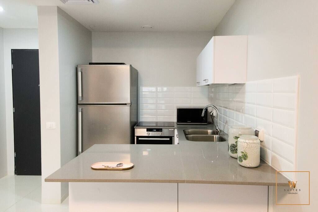 A modern kitchen with stainless steel appliances, a countertop, and white cabinets.