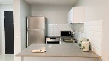 A modern kitchen with stainless steel appliances, a countertop, and white cabinets.