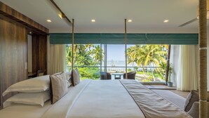 A large bed with multiple pillows, a view of palm trees and a body of water through large windows, and a balcony with a table and chairs. - Amã Stays & Trails Sherly'S Ente Kumbalanghi, Kochi (Kochi)