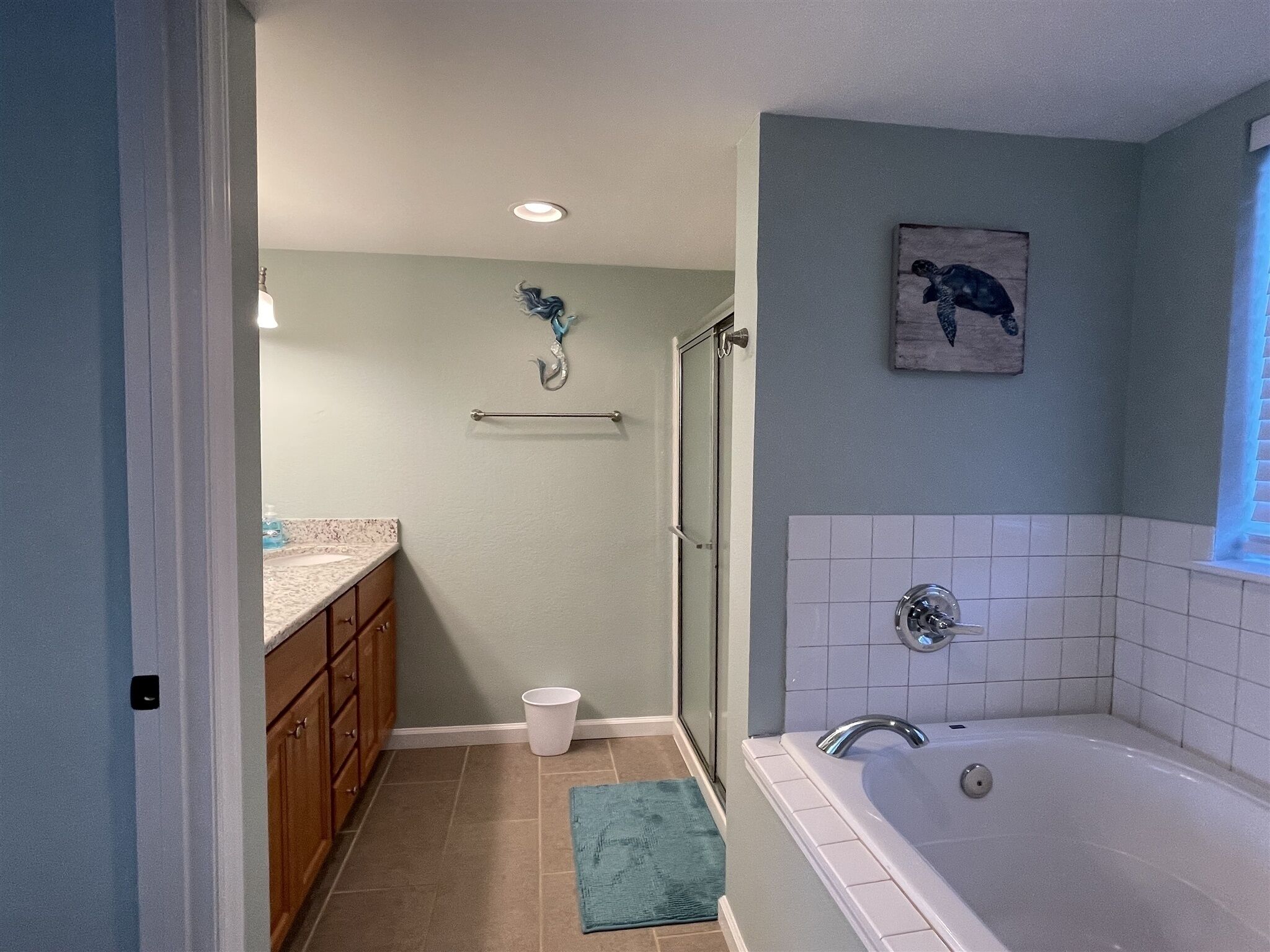 Une salle de bain équipée d’une douche, d’une baignoire, d’un porte-serviettes et de toilettes.