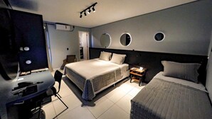 A modern hotel room with a large bed, a desk with a computer, and a TV. - Castro's Hotel (Telemaco Borba)