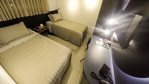 A hotel room with two beds, a desk, a chair, and a TV. - Castro's Hotel (Telemaco Borba)