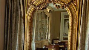 A dining area with ornate gold-framed mirrors, wooden tables, and chairs. - Domaine Du Vivier L'Agneau (Assesse)