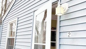 Una casa con el número '2' en la fachada, una puerta y una ventana.