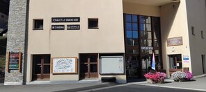 A building with a sign for 'Chalet Le Grand Air' and 'Centrale de Reservation' indicating a cinema and reservation office.