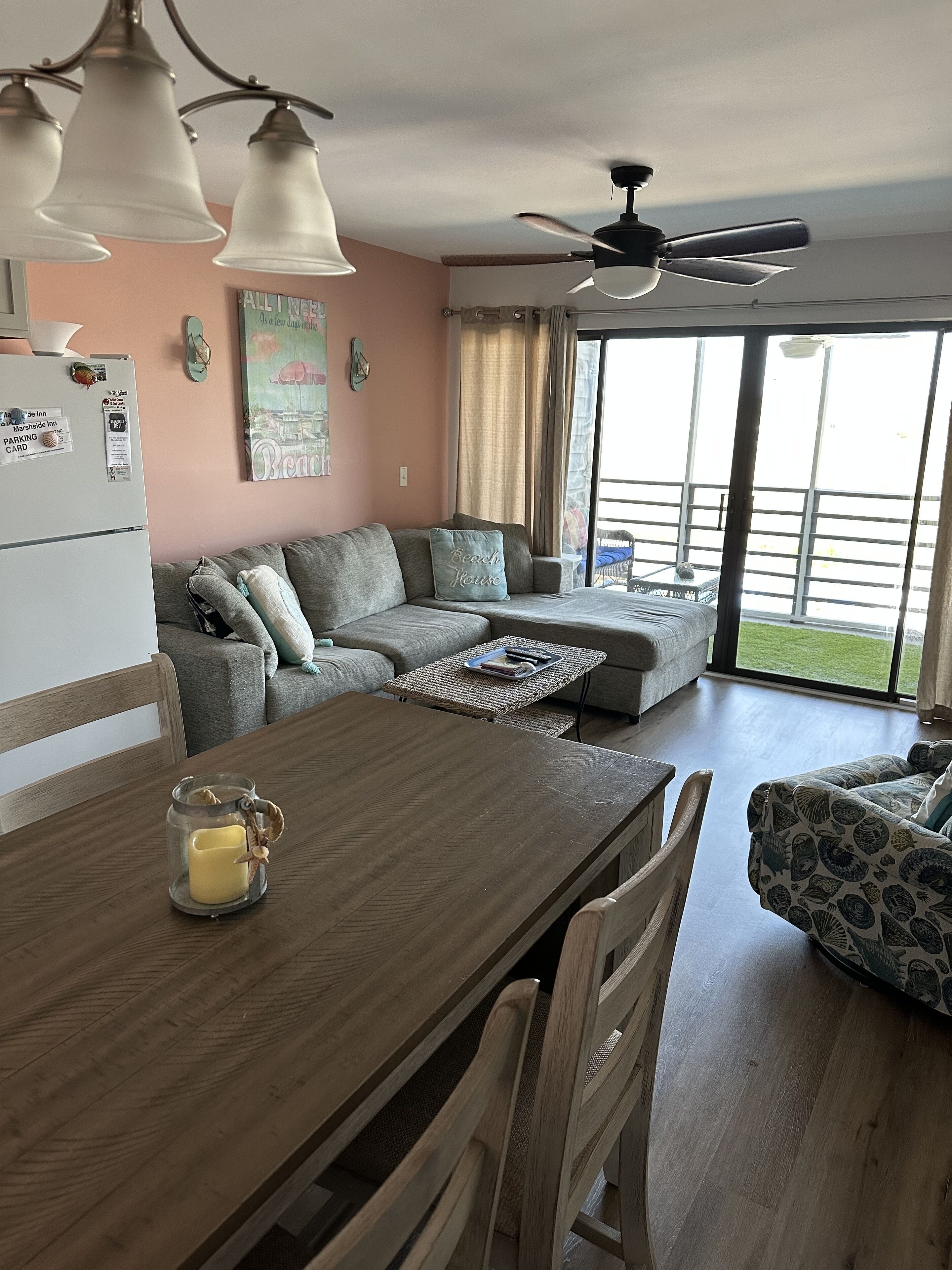 Un salon confortable avec une table à manger, un canapé et un ventilateur de plafond.
