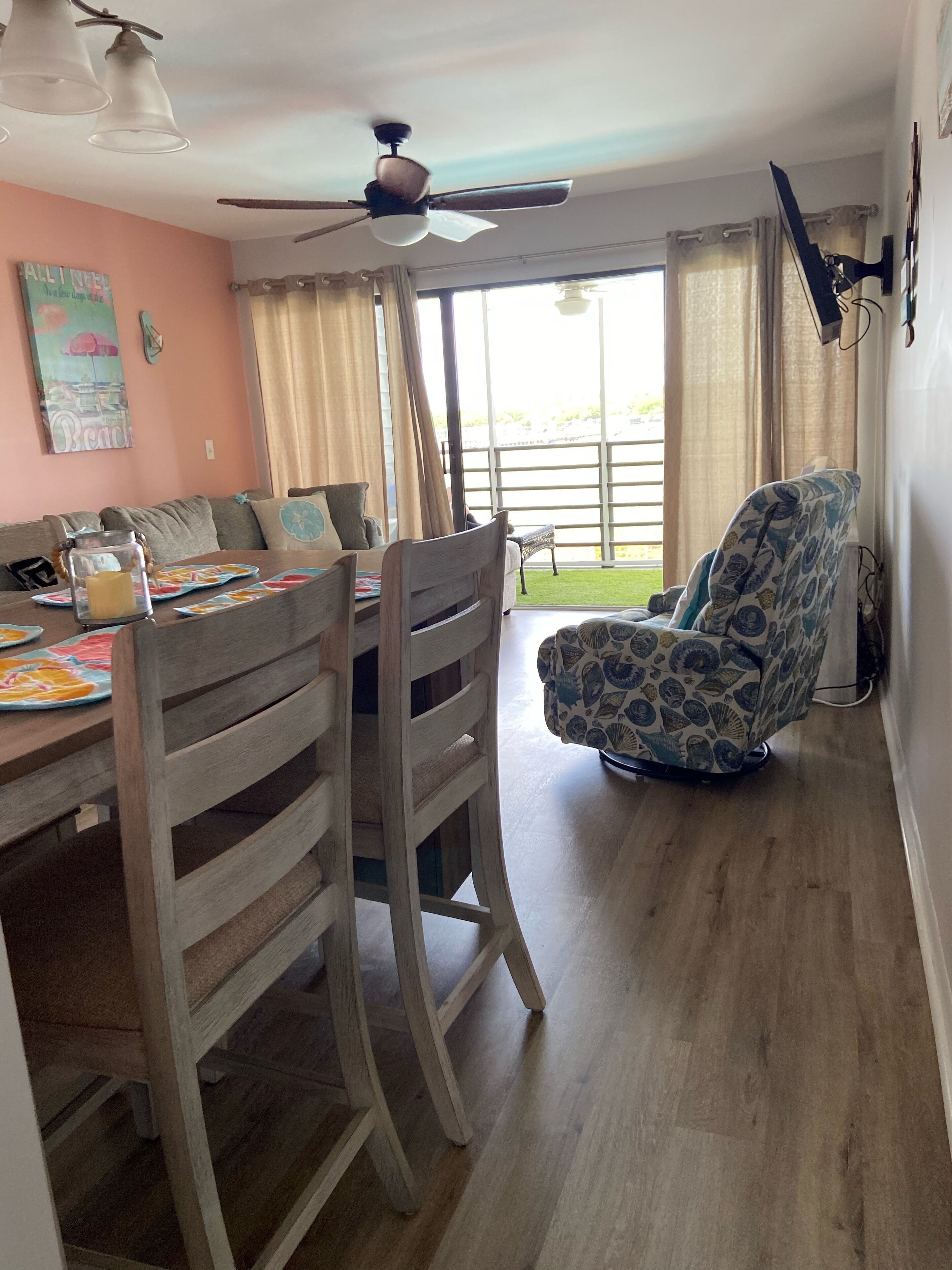 A dining area with a wooden table, chairs, and a ceiling fan.