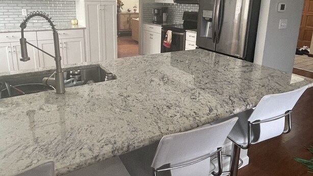 A modern kitchen with a large island, stainless steel appliances, and bar stools. - Fully remodeled 3000sf .home with 3 bedrooms plus  and 2.5 bathrooms  (AURORA)