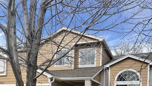 A two-story house with a brick facade, a front porch with red chairs, and a large window with a decorative glass design. - Fully remodeled 3000sf .home with 3 bedrooms plus  and 2.5 bathrooms  (AURORA)