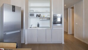 A compact kitchen with a built-in microwave, oven, and sink. - Sweett | Torre Velasca VI (Milano)