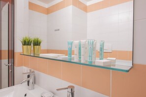 A bathroom with a glass shelf holding toiletries, a sink, and a mirror. - Sweett | Torre Velasca VII (Milano)