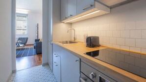 A modern kitchen with a wooden countertop, a built-in sink, and a toaster. - Sweett | Torre Velasca VII (Milano)