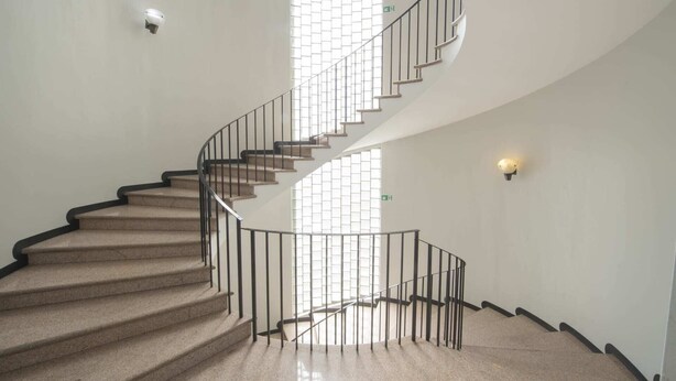Una escalera de caracol con diseño moderno que conduce a un piso superior.