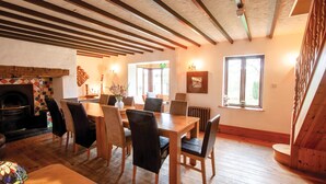 Un espace repas avec des meubles en bois, une cheminée et une vue sur l’extérieur.