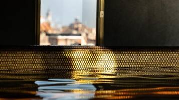 Vista a través de una ventana, con un piso de baldosas que refleja la luz.