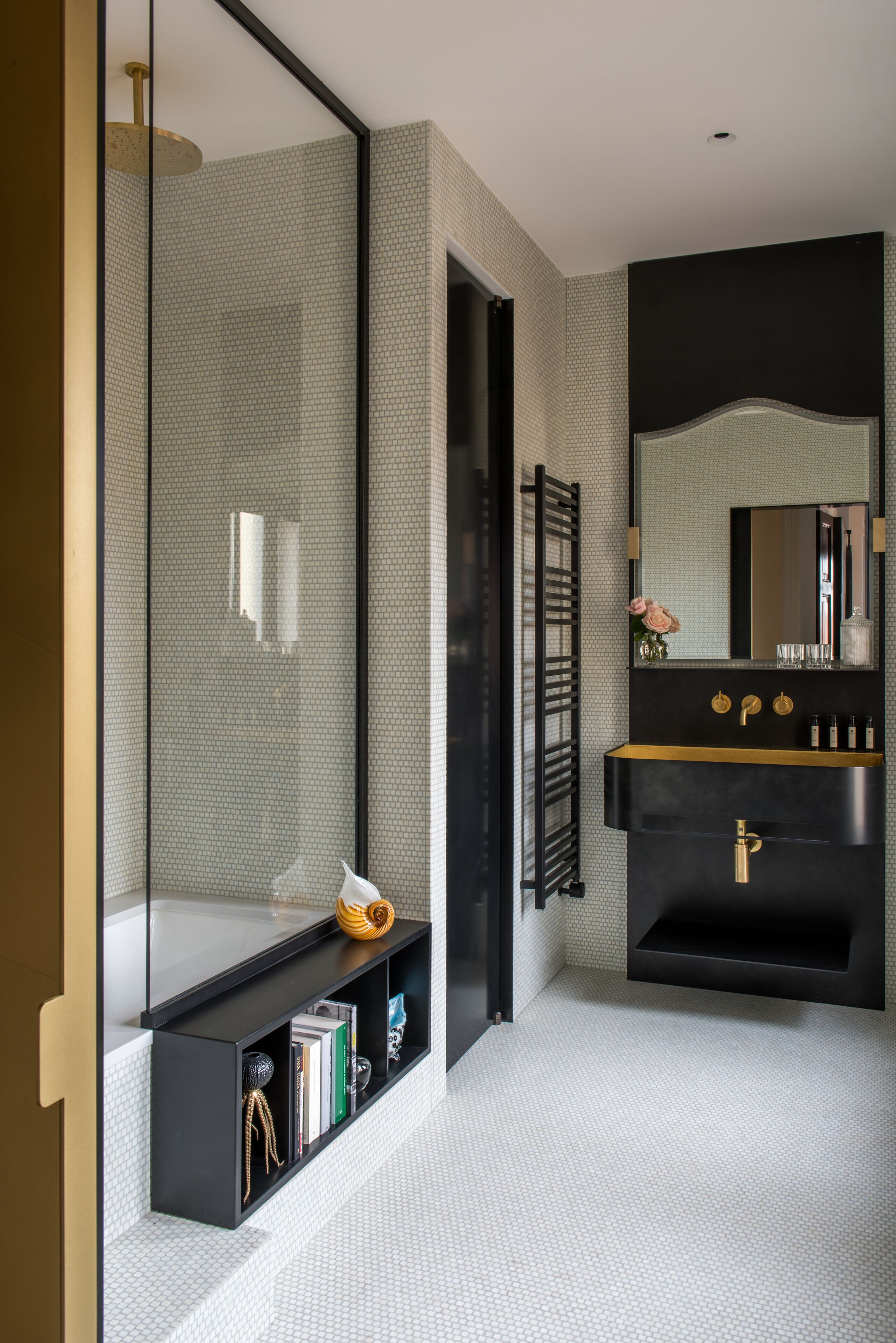 A modern bathroom with a large mirror, a black vanity, and a glass-enclosed shower.