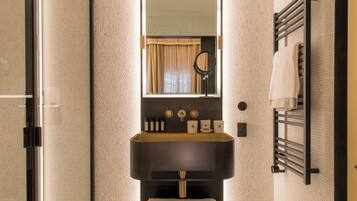 Une salle de bain avec un lavabo noir, un miroir et un porte-serviettes.