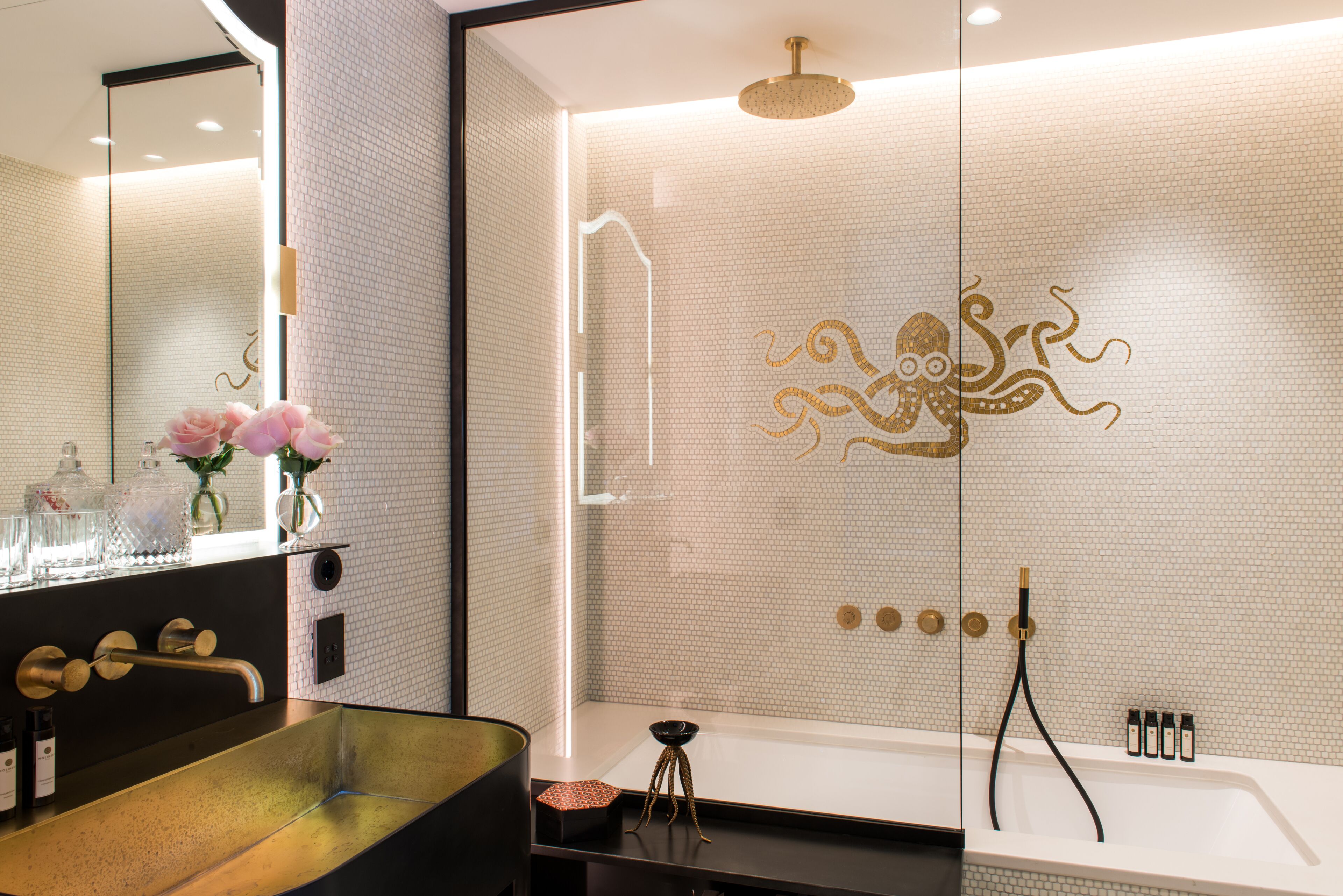 A modern bathroom with a large bathtub, a separate shower area, and a vanity with a sink and mirror.