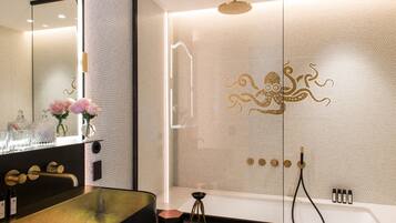 A modern bathroom with a large bathtub, a separate shower area, and a vanity with a sink and mirror.