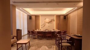Un grand espace dédié à la salle à manger, avec une table ronde, plusieurs chaises et un petit coin bar.