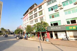 A street view with buildings, shops, and a clear sky. - Landscape Hotel (Zhangping)