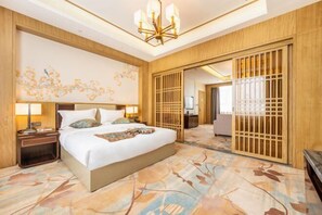 Une chambre d’hôtel avec un grand lit, une table de chevet avec une lampe, un mur décoratif et une cloison en bois.
